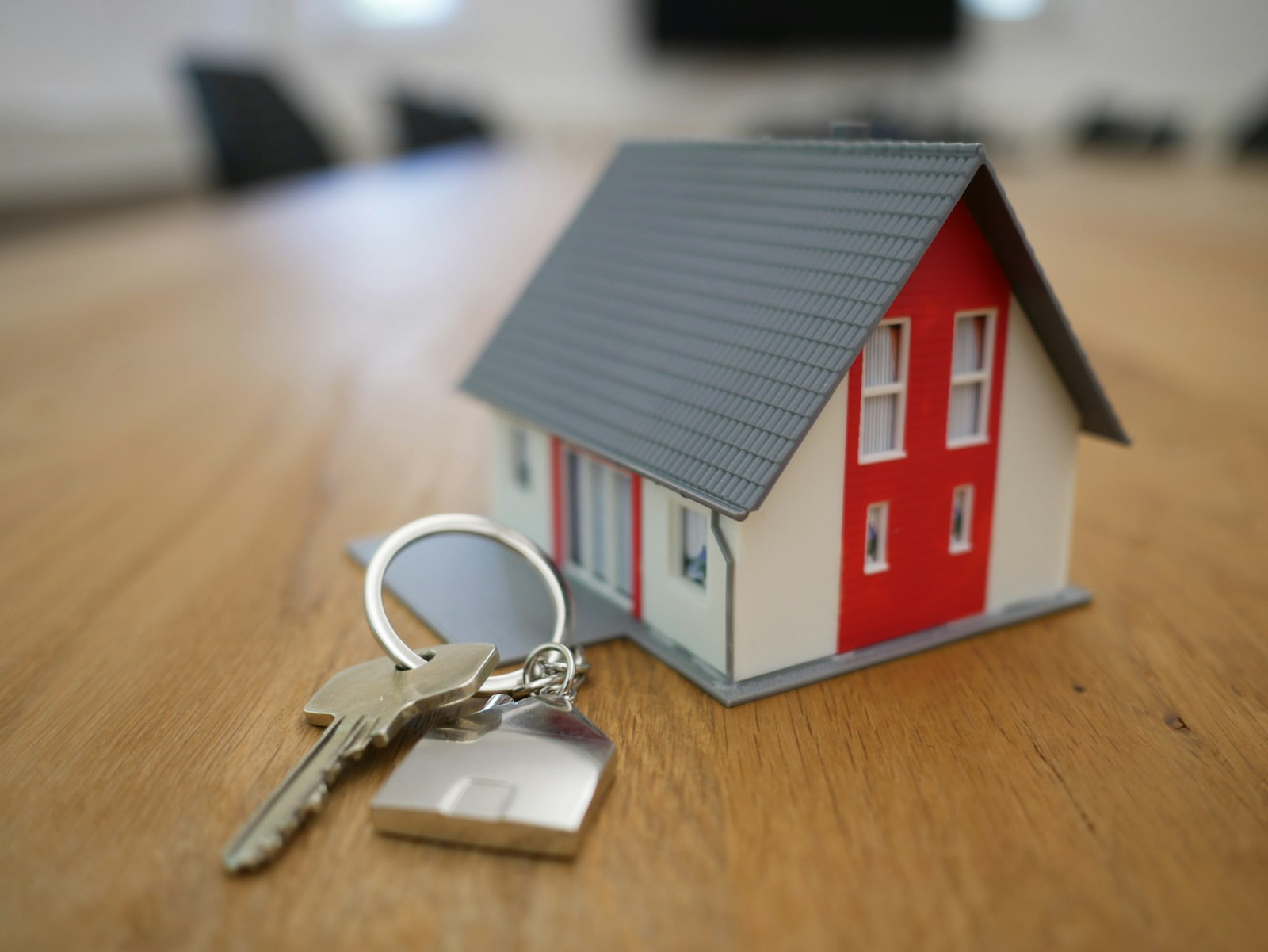 Miniature house model with keys on a table representing real estate investment and cap rates